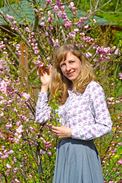 La jeune femme parmi les buissons florissants d'amandes à trois lames — Photo