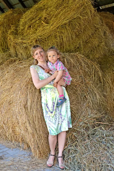 年轻女子的肖像与女儿在割草 — 图库照片