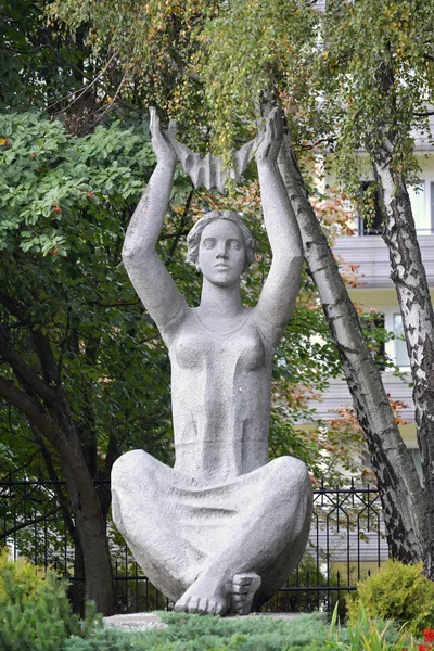 SVETLOGORSK, RUSSIA - SEPTEMBER 21, 2014: A sculpture the sitting woman with the raised hands — Stock Photo, Image