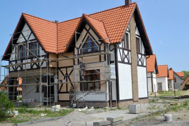 KALININGRAD REGION, RUSSIA - JUNE 01, 2016: Finishing works on a  facade of a new cottage clipart