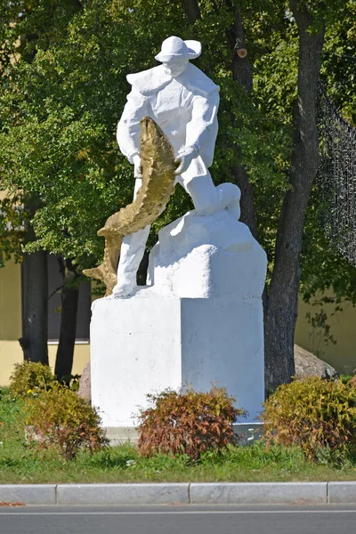 PIONEER, RUSIA - 22 de agosto de 2015: Un monumento al pescador con un esturión en las manos —  Fotos de Stock