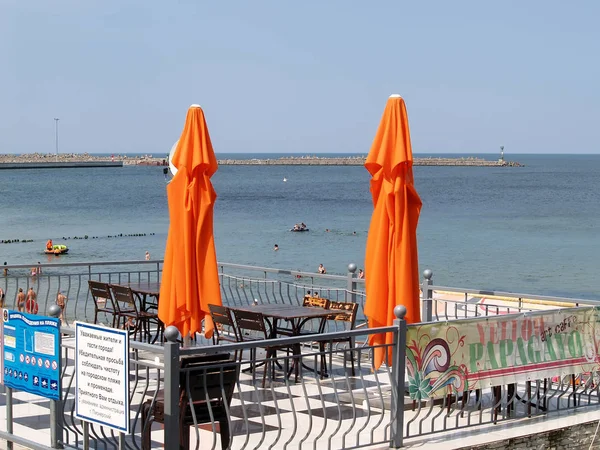 PIONEER, RUSSIA - AUGUST 02, 2012: Two beach orange umbrellas against the background of the Baltic Sea — Stock Photo, Image