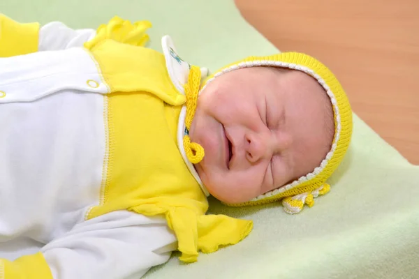 O bebê adormecido em um gorro amarelo — Fotografia de Stock