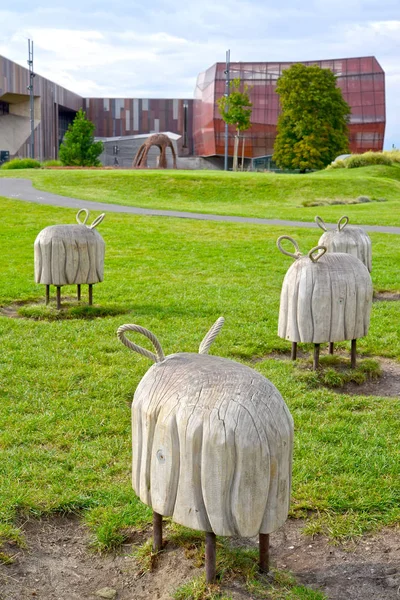 Warschau, Polen - 23. August 2014: dekorative Holzskulpturen von Schafen im Park der Öffnungen vor dem Hintergrund des Planetariumsgebäudes. Zentrum der Wissenschaft des Kopernikus — Stockfoto