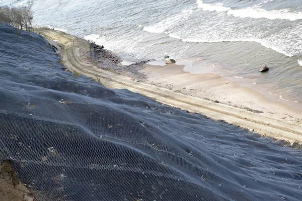 Engineering protection of a landslide slope with reinforcing mesh with anchorage on the seashore.  Svetlogorsk, Kaliningrad region — Stock Photo, Image