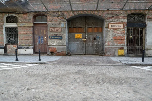 WARSAW, POLAND - AUGUST 28, 2014: The old building with signs of workshops on a facade. Polish text "shoemaker, tailor" — Stock Photo, Image