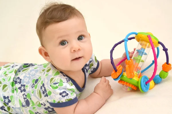 Portrait of the baby with a toy on a light background — Stock Photo, Image