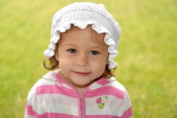 小女孩在绿色背景上的白色巴拿马的肖像 — 图库照片