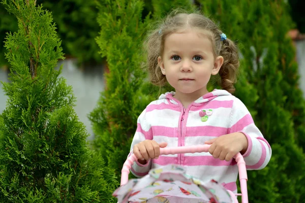 Portrait de la petite fille sur fond de plantes résineuses — Photo