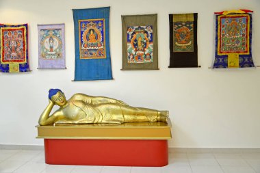 ELISTA, RUSSIA - APRIL 22, 2017: A sculpture of the lying Buddha  Shakyamuni and fabric icons tanks. National museum of Kalmykia of N. N. Palmov clipart