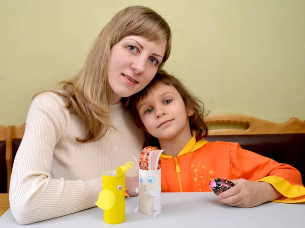 Молодая женщина и маленькая дочь с самодельными опорами для пасхального яйца — стоковое фото