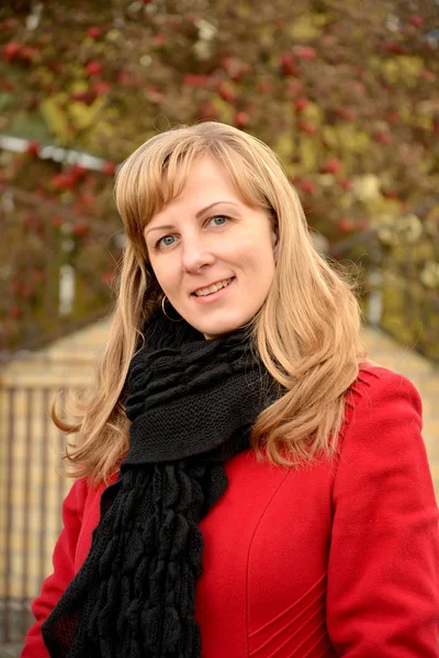 Portrait of the happy young woman in a red coat — Stock Photo, Image