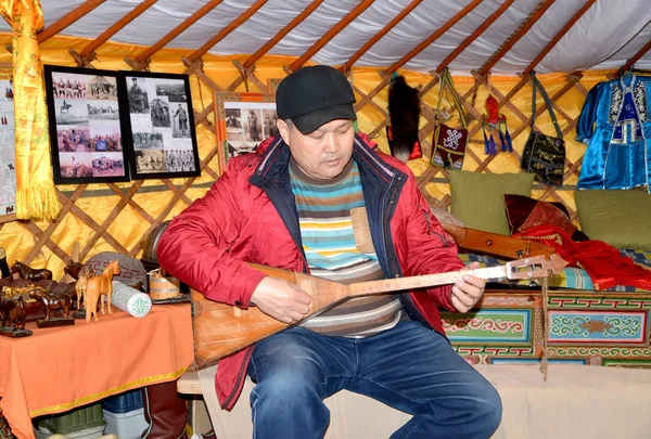 ELISTA, RUSSIA - APRIL 22, 2017: The Kalmyk man plays on a dombra in the tilt cart — Stock Photo, Image