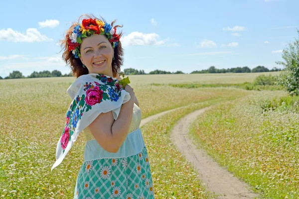 La femme joyeuse avec une couronne sur la tête sur le fond du champ de sarrasin en fleurs — Photo