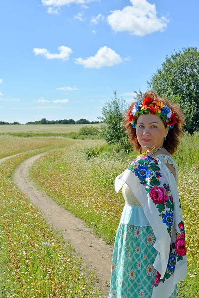 Portrait de la femme avec une couronne sur la tête au bord du champ de sarrasin en fleurs — Photo