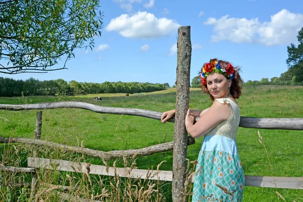 Kafasına bir çelenk ile ortalama yıl kadın bir çit durumda