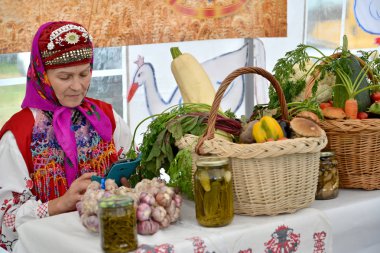 Kaliningrad bölgesi, Rusya Federasyonu - 05 Ağustos 2017: Milli takım elbiseli kadın tarımsal üretim kırsal fuarında satıyor 