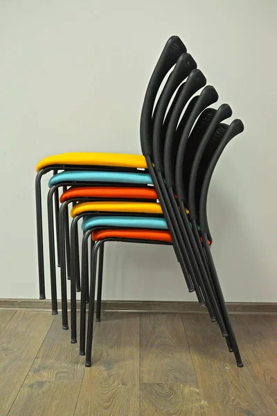 Kancelářské židle jsou vloženy s barevných křesel v zásobníku. Boční pohled — Stock fotografie