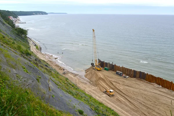 Byggandet av en tunga-och-spår skydd på kusten av Östersjön — Stockfoto