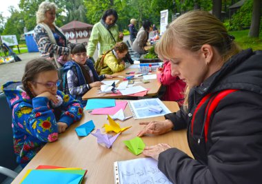 Kaliningrad, Rusya Federasyonu - 17 Eylül 2017: Genç kadın origami koyar. Açık havada çocuk ana sınıfı