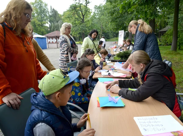 Kaliningrad, Rusya - 17 Eylül 2017: Çocuklara öğretmen gösterir origami katlama. Açık havada çocuk ana sınıfı — Stok fotoğraf