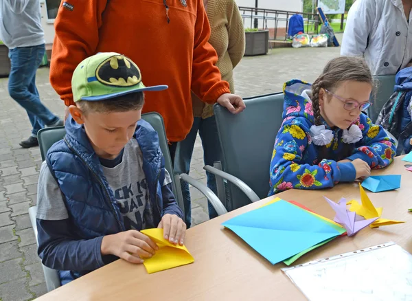 KALINININGRAD, RUSIA - 17 DE SEPTIEMBRE DE 2017: Los niños aprenden a poner origami. Clase magistral para niños al aire libre — Foto de Stock
