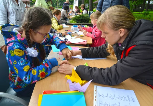 Kaliningrad, Rusya Federasyonu - 17 Eylül 2017: Origami koymak için kız öğretmen öğretir. Açık havada çocuk ana sınıfı — Stok fotoğraf