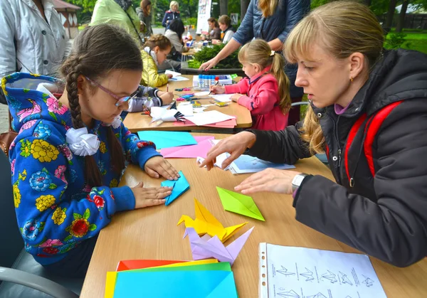 KALINININGRAD, RÚSSIA - SETEMBRO 17, 2017: A menina coloca origami. Master class das crianças em aberto ai — Fotografia de Stock