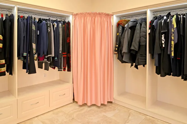 Stojaki z ubrania i skośne przymierzalni w kabinie w sklepie — Zdjęcie stockowe