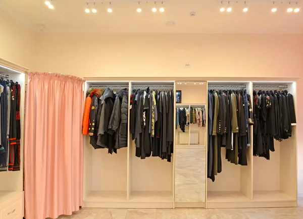 Regály s oblečením a šatna na chatě v obchodě — Stock fotografie