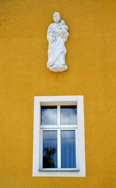 Szent József szobor a gyermek Jézus Krisztus a falon a az épület a római katolikus plébánia. Gvardeysk, kalinyingrádi — Stock Fotó