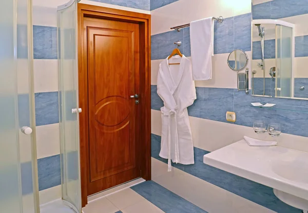 Interior del baño con una bata de baño en una pared —  Fotos de Stock