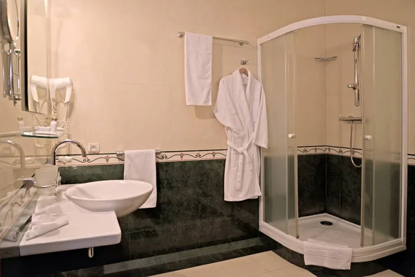 Bathroom interior with a shower booth and a bath robe — Stock Photo, Image