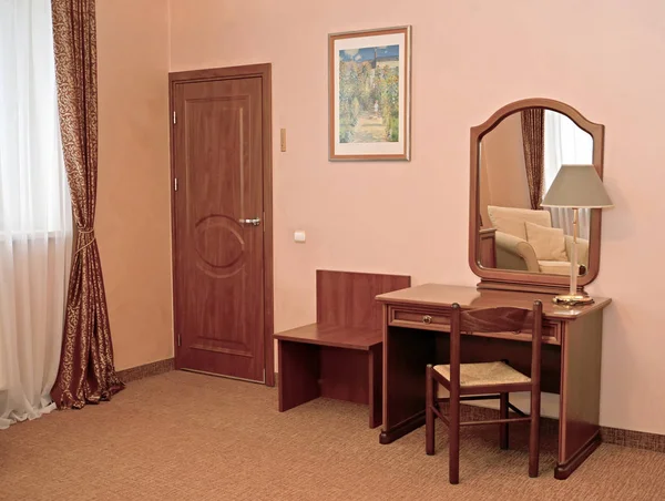 A fragment of an interior of the hotel room with a desktop mirror
