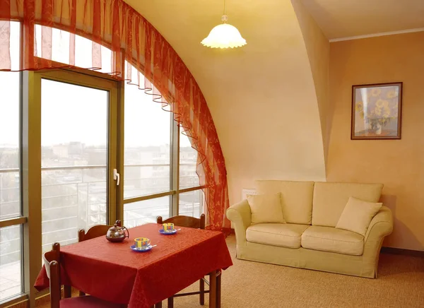 Un fragmento interior de la sala de estar con un lambrequín rojo en una ventana y una imagen en una pared —  Fotos de Stock