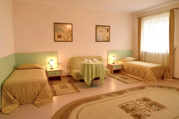 Спальня с двумя кроватями и диваном в классическом стиле — стоковое фото