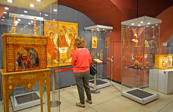 КАЛИНИНГРАД, РОССИЯ - 28 марта 2018 года: Посетитель рассматривает янтарную икону на выставке в музее янтаря — стоковое фото