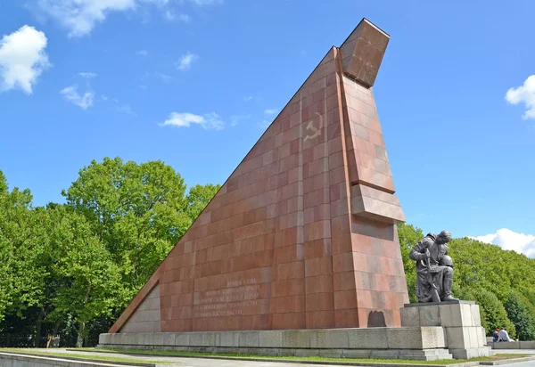 BERLÍN, ALEMANIA - 13 DE AGOSTO DE 2017: Una escultura del soldado afligido sobre el bajó una pequeña bandera de granito. Treptov-parque —  Fotos de Stock