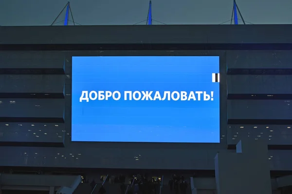 KALINININGRAD, RUSIA: 11 DE ABRIL DE 2018: El panel indicativo con la inscripción "¡Bienvenidos!" sobre una entrada al estadio Baltic Arena. El texto en ruso - Bienvenido . — Foto de Stock