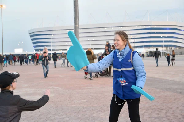 КАЛИНИНГРАД, РОССИЯ - 11 апреля 2018 года: Волонтер чемпионата мира по футболу 2018 года с указателем на руке. Стадион Балтийской арены — стоковое фото