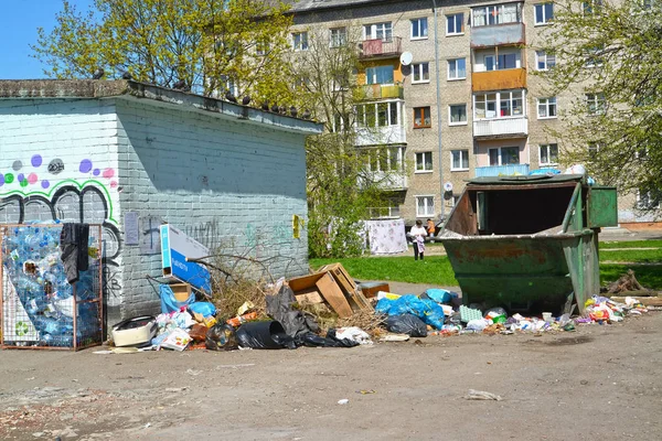 КАЛИНИНГРАД, РОССИЯ - 20 апреля 2018 года: Свалка бытовых отходов вокруг мусорного контейнера — стоковое фото