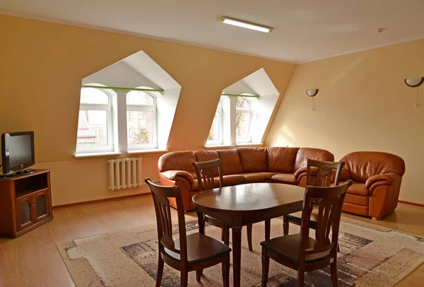 Woonkamer interieur met bruin meubilair en een leerbank en een stoel — Stockfoto