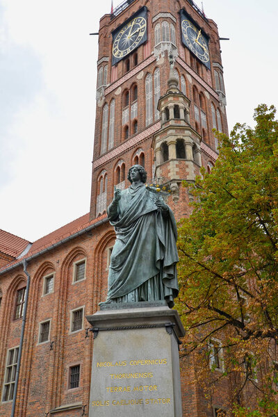 Памятник Николаю Копернику 1853 года на фоне часовой башни старой ратуши. Торунь, Польша
