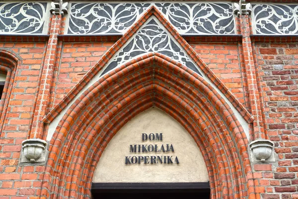 Fragmento de la fachada del antiguo edificio con la inscripción en polaco "Casa de Nicolás Copérnico" (siglo XV). Torun, Polonia — Foto de Stock