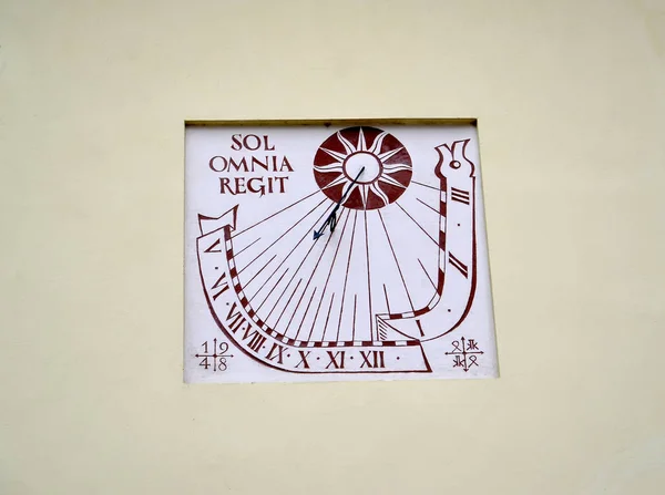 FROMBORK, POLAND - JULY 09, 2015: A solar watch on the wall of a building reading in Latin "sol omnia regit." Latin text - The Sun dominates everything — Stock Photo, Image