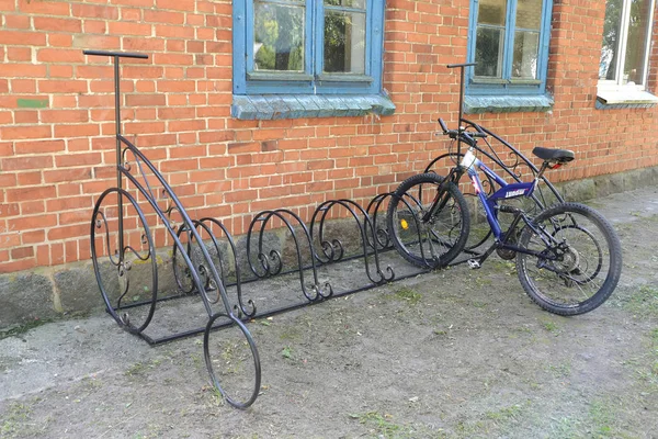 REGIÓN DE KALINININGRAD, RUSIA - 20 DE JULIO DE 2019: Estacionamiento de bicicletas con bicicleta estacionada cerca del edificio de ladrillo —  Fotos de Stock