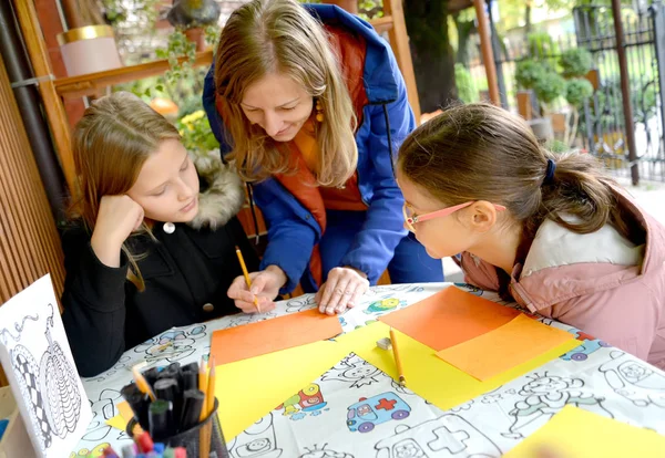 KALININGRAD, RUSSIE - 13 OCTOBRE 2019 : Un enseignant travaille avec des enfants sur du papier coloré. Classe de maître extérieure pour enfants — Photo