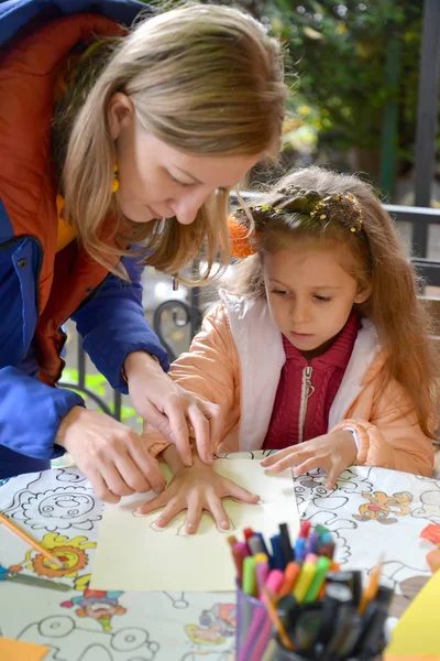 KALININGRAD, RUSSIE - 13 OCTOBRE 2019 : L'enseignant décrit la main de l'enfant sur papier. Classe de maître extérieure pour enfants — Photo