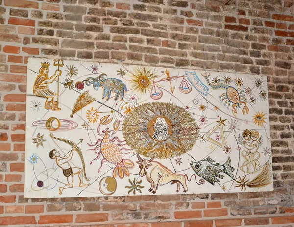 FROMBORK, POLOGNE - 09 JUILLET 2015 : Stand avec des dessins d'enfants de signes du zodiaque et un portrait de Nikolaï Copernic sur un mur de briques — Photo