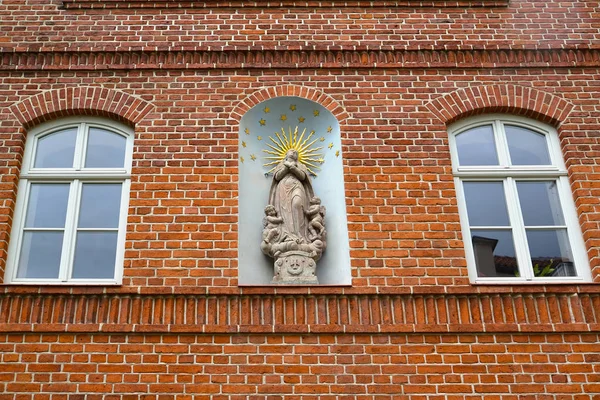 Statue of the ascension of Maria Magdalene in the niche of the brick wall of the building, 1667. Frombork, Poland — Stock Photo, Image